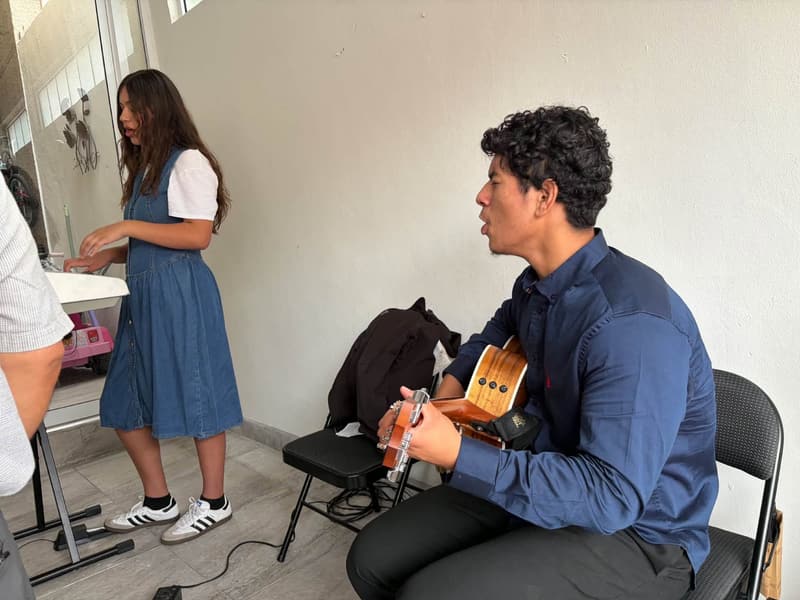 A young man playing guitar during worship at the Tijuana church.